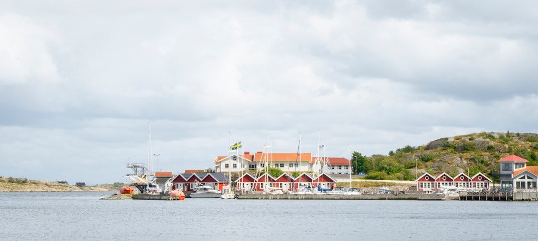 Small Danish fishing village harbor with colorful wooden boats and cottages