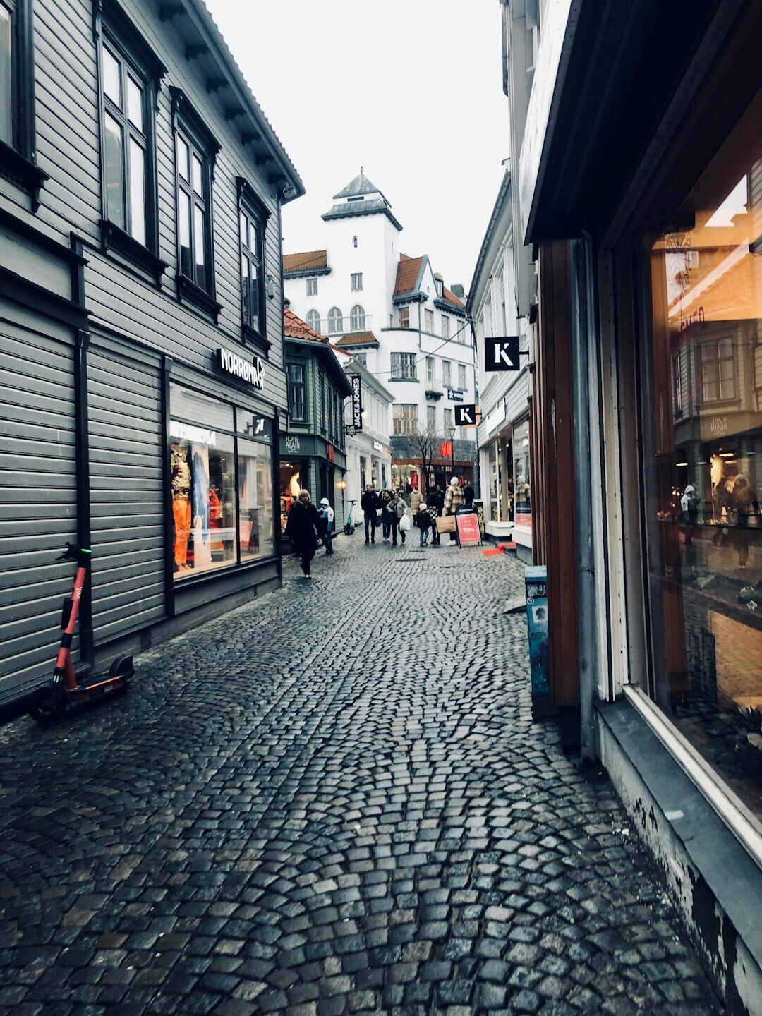 Narrow cobblestone street with pedestrians in an old Danish market town