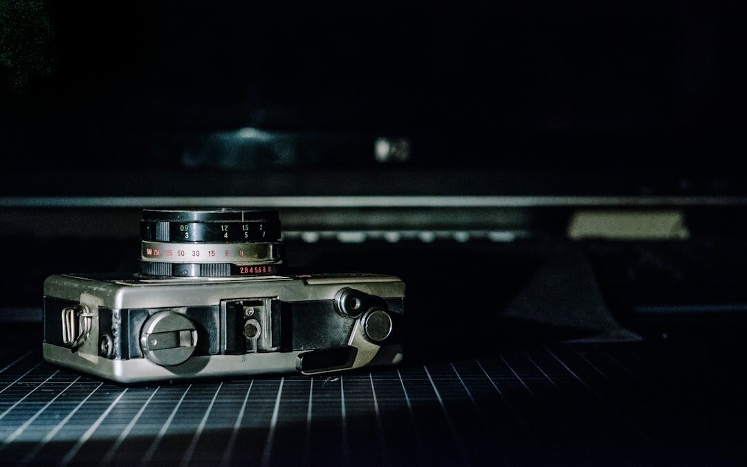 Vintage film camera and notebook resting on a wooden desk